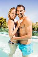 Happy couple in the pool embracing