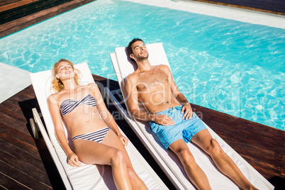 Cute couple relaxing on deckchairs