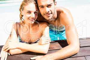 Happy couple leaning on pool edge