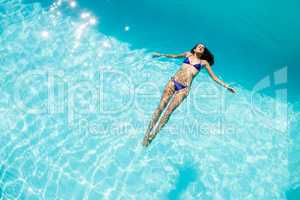 Calm woman floating in the pool