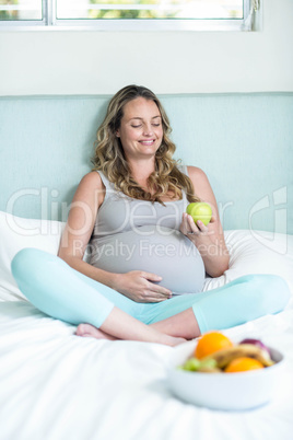 Pregnant woman holding an apple