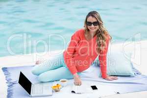 Pregnant woman relaxing outside and using laptop