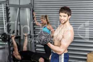 Shirtless man lifting dumbbells