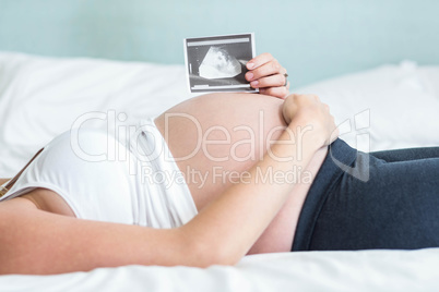 Pregnant woman showing an ultrasound picture