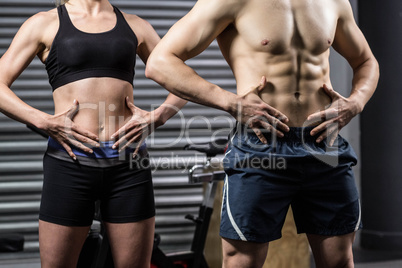 Midsection of fit couple posing