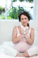 Pregnant woman sitting on bed