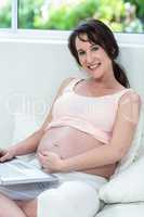 Pregnant woman relaxing with her laptop