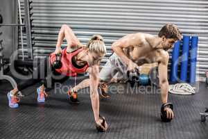 Couple doing push up with dumbbells