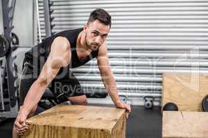 Fit man moving wooden box