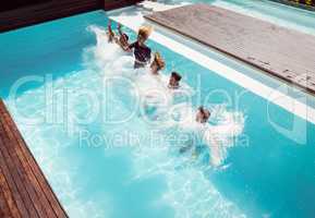 Happy friends jumping in the pool