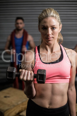 Portrait of fit woman lifting dumbbells