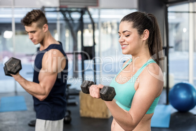 Fit people lifting dumbbells