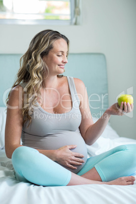 Pregnant woman holding an apple