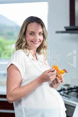 Pregnant woman eating fruits salad