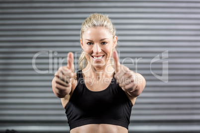 Fit woman showing thumbs up