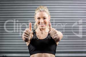 Fit woman showing thumbs up