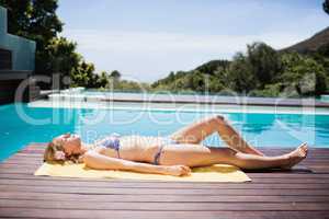 Smiling woman in bikini lying on towel