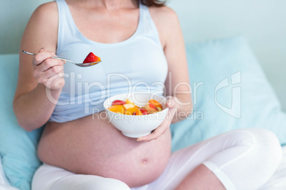 Pregnant woman eating fruit