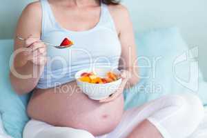 Pregnant woman eating fruit