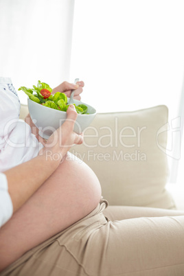 Pregnant woman eating salad