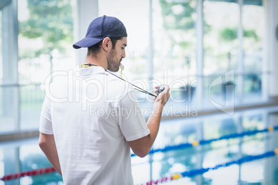 Serious trainer looking at stopwatch
