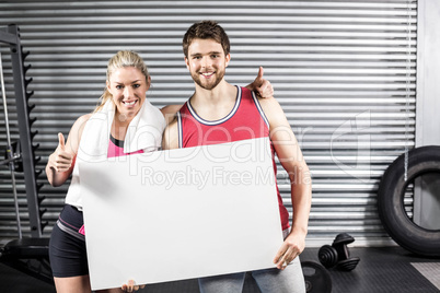 Fit couple holding blank paper