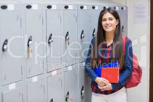 Smiling student posing near locker