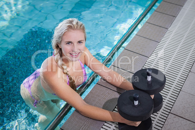 Attractive woman lifting dumbbells