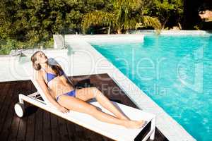 Fit brunette lying on deck chair