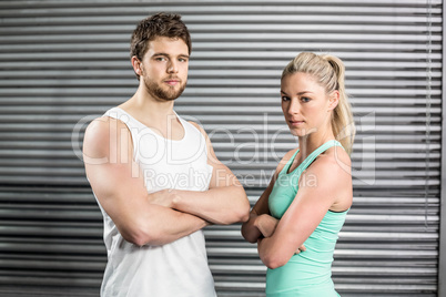 Fit couple posing with arms crossed