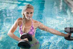 Attractive woman lifting dumbbells