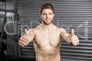 Shirtless fit man with thumbs up