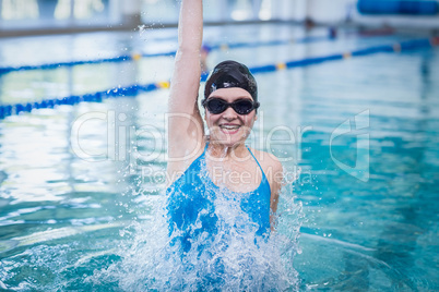 Fit woman triumphing with raised arm