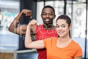 Smiling woman and man contracting biceps