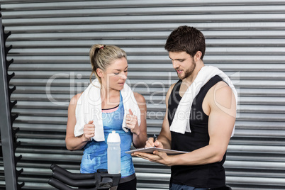 Smiling fit couple taking notes