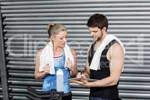 Smiling fit couple taking notes