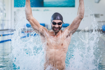 Smiling man triumphing with raised arms