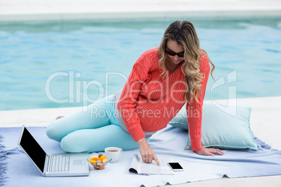 Pregnant woman relaxing outside and using laptop