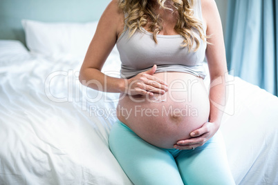 Pregnant woman applying cream on her belly