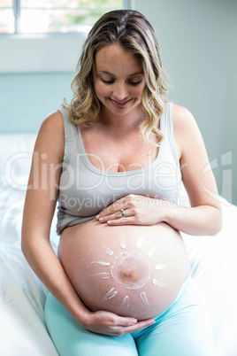 Pregnant woman applying cream on her belly