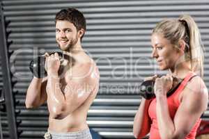 Couple lifting dumbbells together