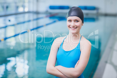Cute woman wearing swim cap with arms crossed