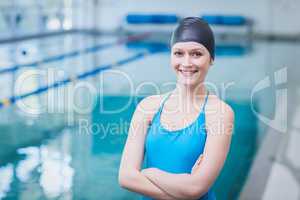 Cute woman wearing swim cap with arms crossed