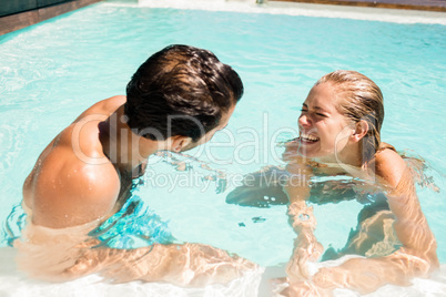 Happy couple laughing in the pool