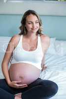 Pregnant woman resting on her bed