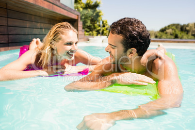 Happy couple with lilos in the pool