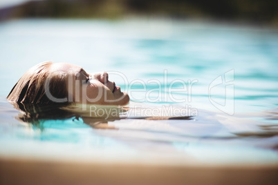 Peaceful blonde floating in the pool