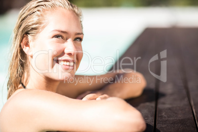 Smiling blonde leaning on pools edge