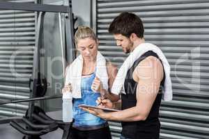 Smiling fit couple taking notes