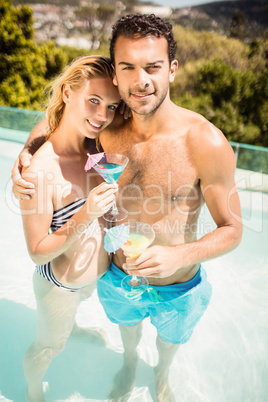 Happy couple holding cocktails